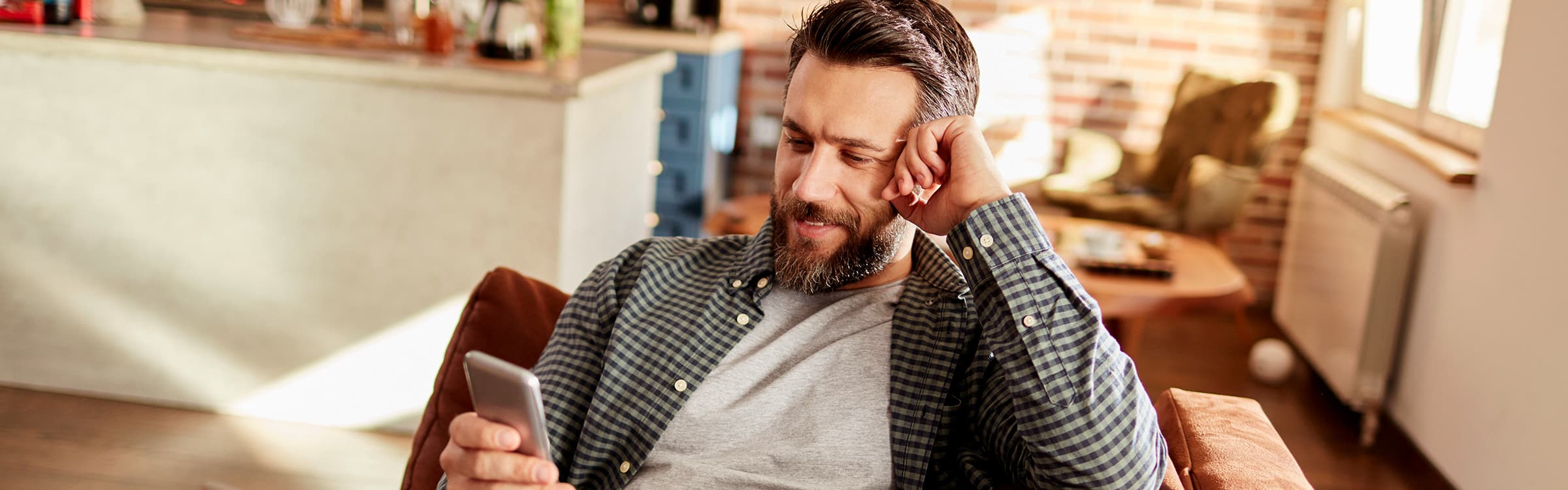 Ein Mann guckt auf sein Handy und lacht