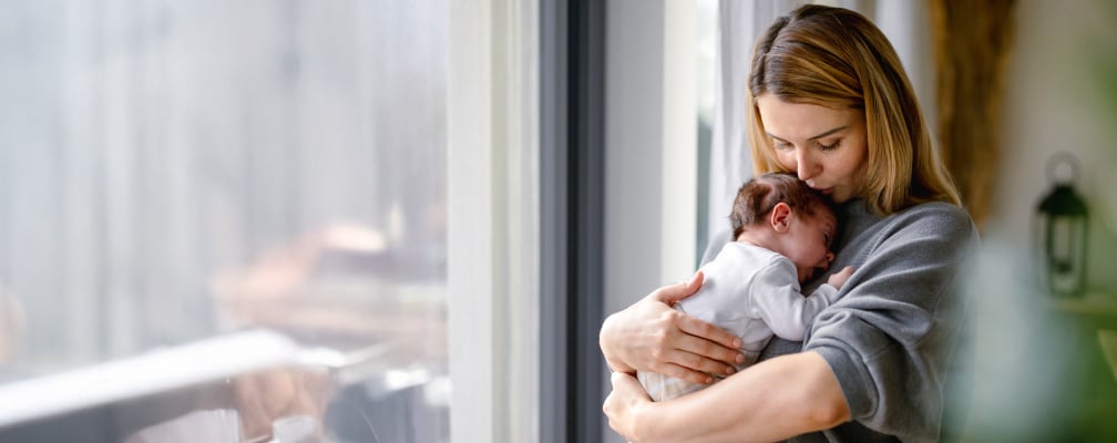 Eine Frau hält ein Baby im Arm.