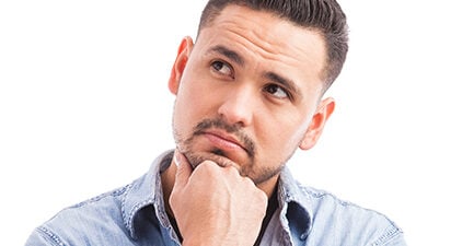 Mann steht in Gedanken da und fragt sich "Liebt sie mich?"