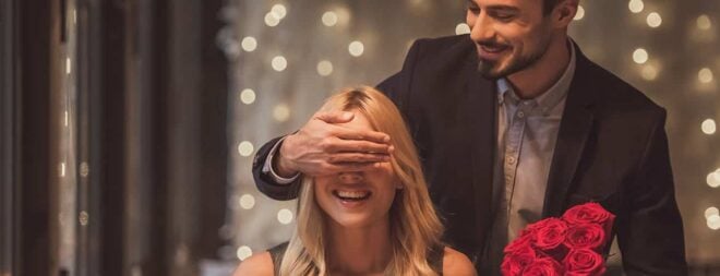 Romantische Ideen: Mann schenkt Frau rote Rosen